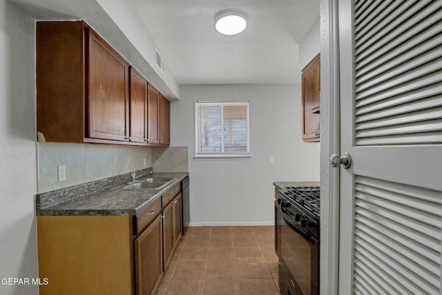 kitchen with light tile patterned floors, a textured ceiling, sink, black dishwasher, and stove