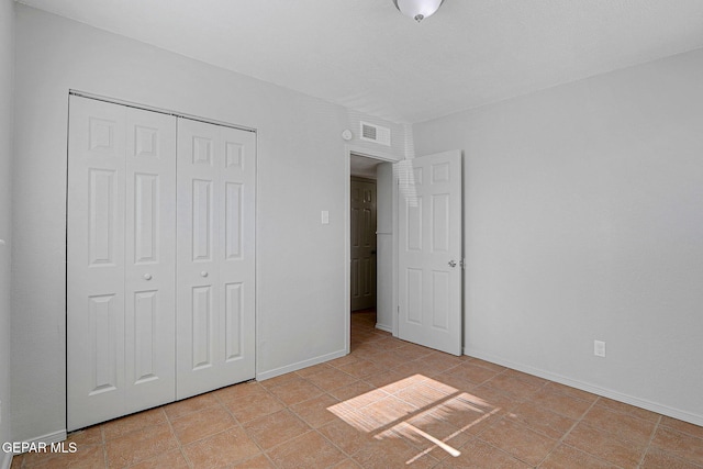 unfurnished bedroom featuring a closet and light tile patterned floors