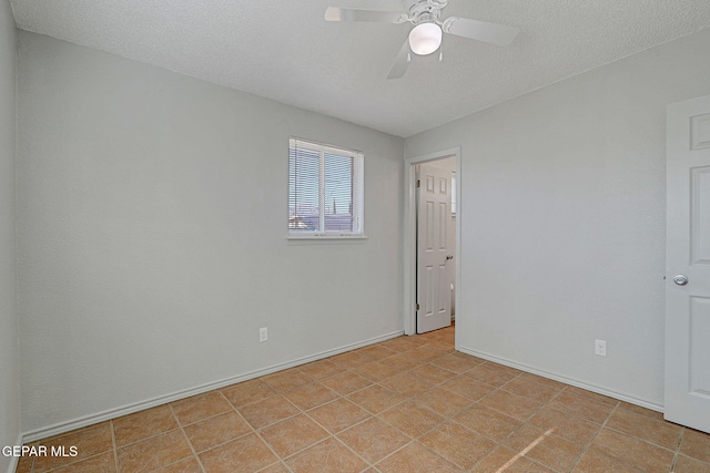 tiled spare room featuring a textured ceiling and ceiling fan