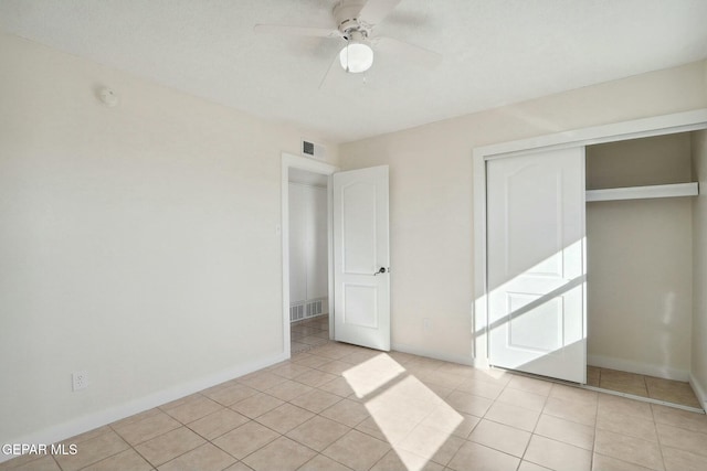 unfurnished bedroom with ceiling fan, a closet, and light tile patterned flooring