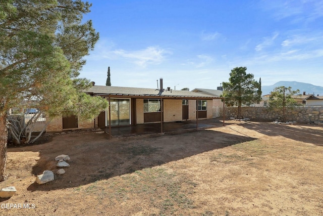 back of property featuring a mountain view and a patio area