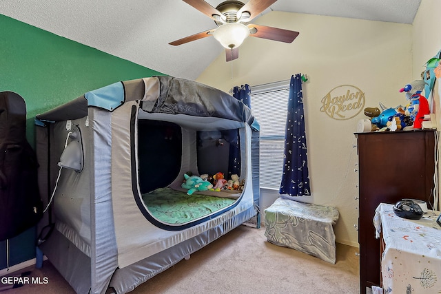 bedroom featuring ceiling fan, carpet floors, lofted ceiling, and a textured ceiling