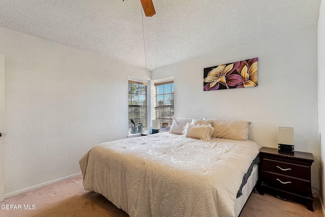 bedroom with ceiling fan, light colored carpet, and a textured ceiling