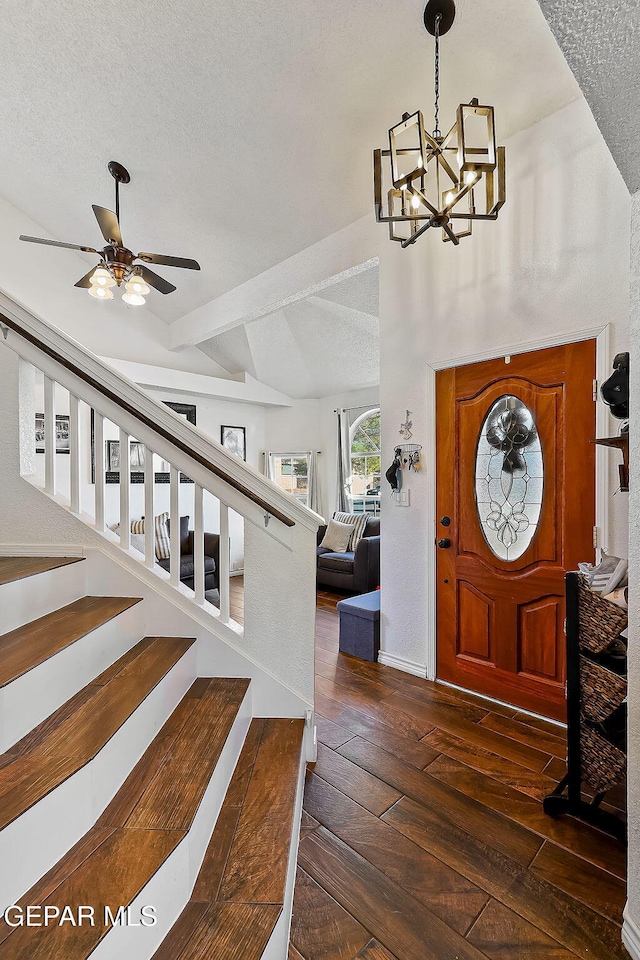 foyer featuring a textured ceiling, dark hardwood / wood-style flooring, lofted ceiling with beams, and ceiling fan with notable chandelier