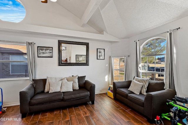 living room with a textured ceiling and vaulted ceiling with beams