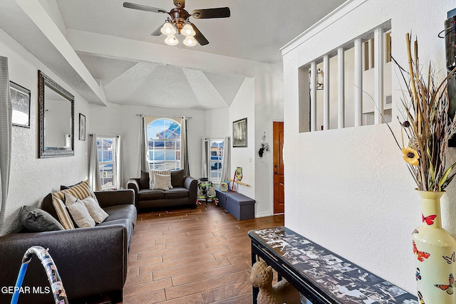 living room featuring a textured ceiling, ceiling fan, and vaulted ceiling