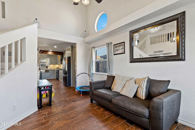 living room featuring a towering ceiling and ceiling fan