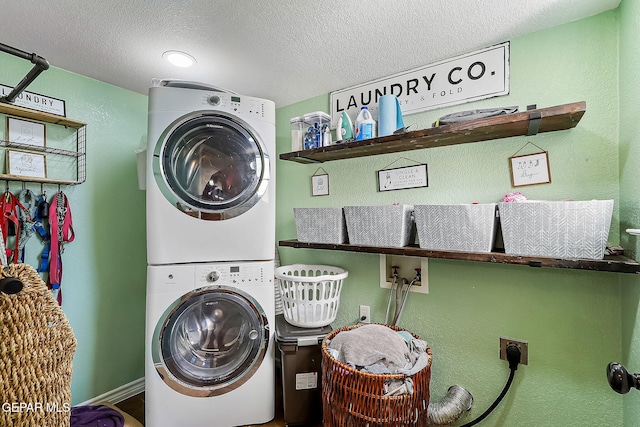 washroom featuring stacked washing maching and dryer and a textured ceiling