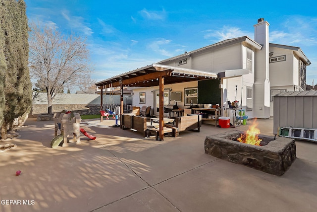 view of patio featuring an outdoor living space with a fire pit