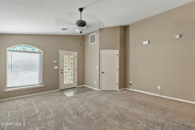 spare room with ceiling fan, light carpet, and vaulted ceiling