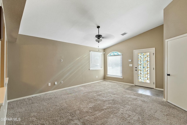 interior space featuring ceiling fan, light carpet, and lofted ceiling