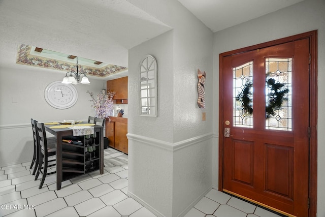 foyer with a chandelier and a tray ceiling