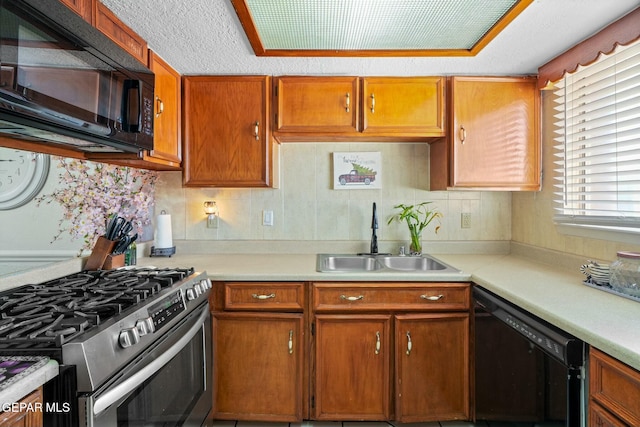 kitchen featuring black appliances, a healthy amount of sunlight, a textured ceiling, and sink