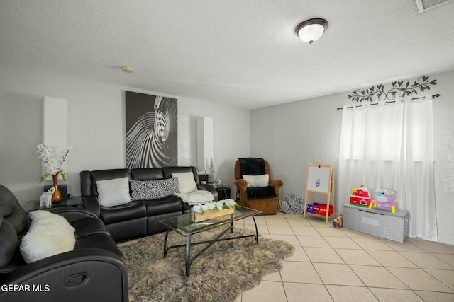 tiled living room featuring a textured ceiling