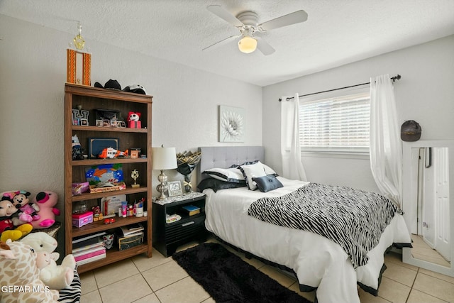 tiled bedroom with ceiling fan and a textured ceiling