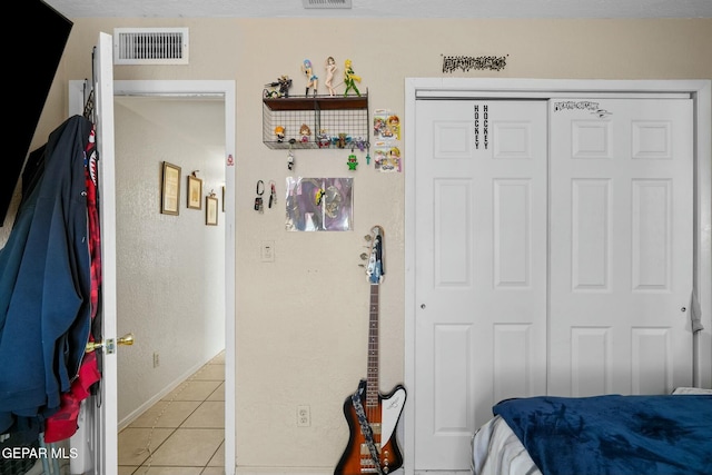 tiled bedroom with a closet