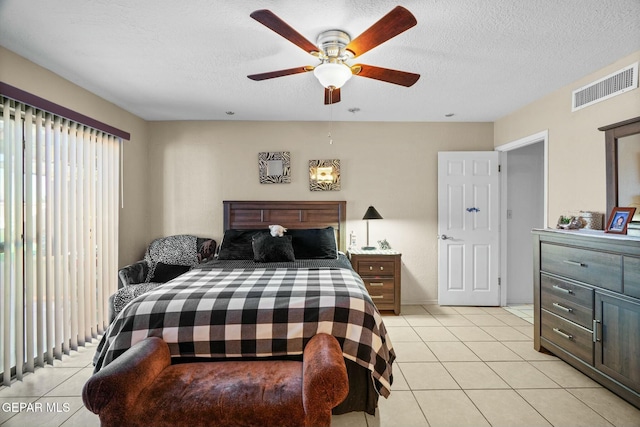 tiled bedroom with a textured ceiling and ceiling fan