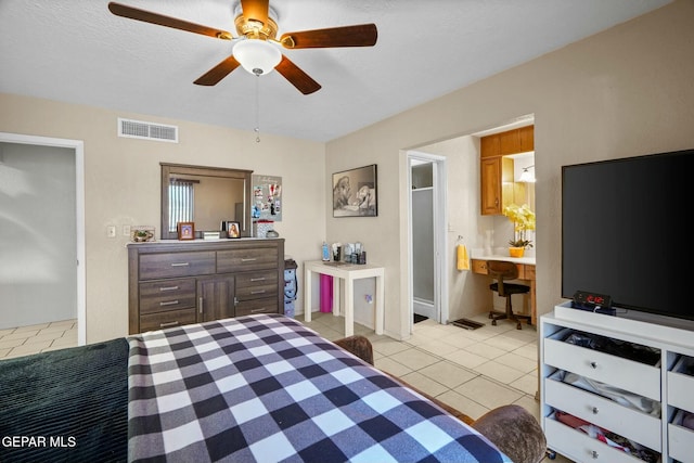 bedroom featuring ceiling fan, ensuite bath, a textured ceiling, and light tile patterned floors