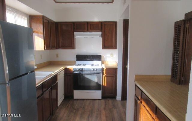 kitchen featuring dark wood-type flooring, sink, and white appliances