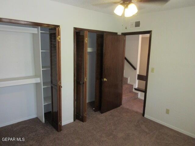 unfurnished bedroom featuring ceiling fan, a closet, and dark carpet