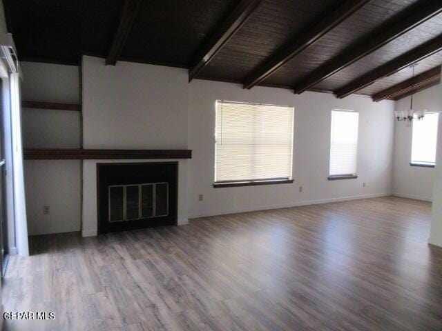 unfurnished living room with hardwood / wood-style floors, lofted ceiling with beams, wood ceiling, and an inviting chandelier