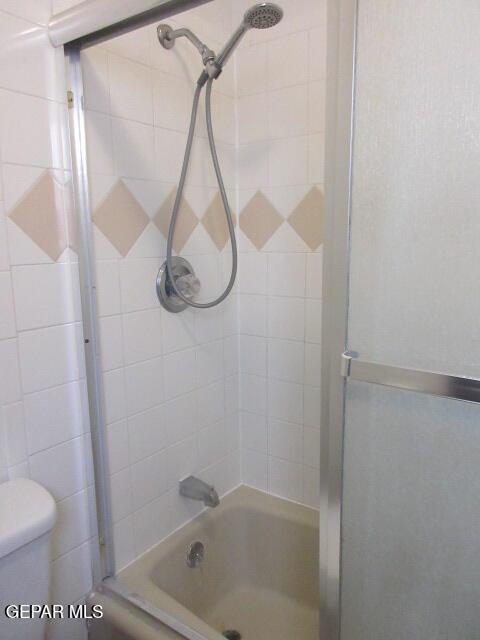 bathroom with toilet and tiled shower / bath