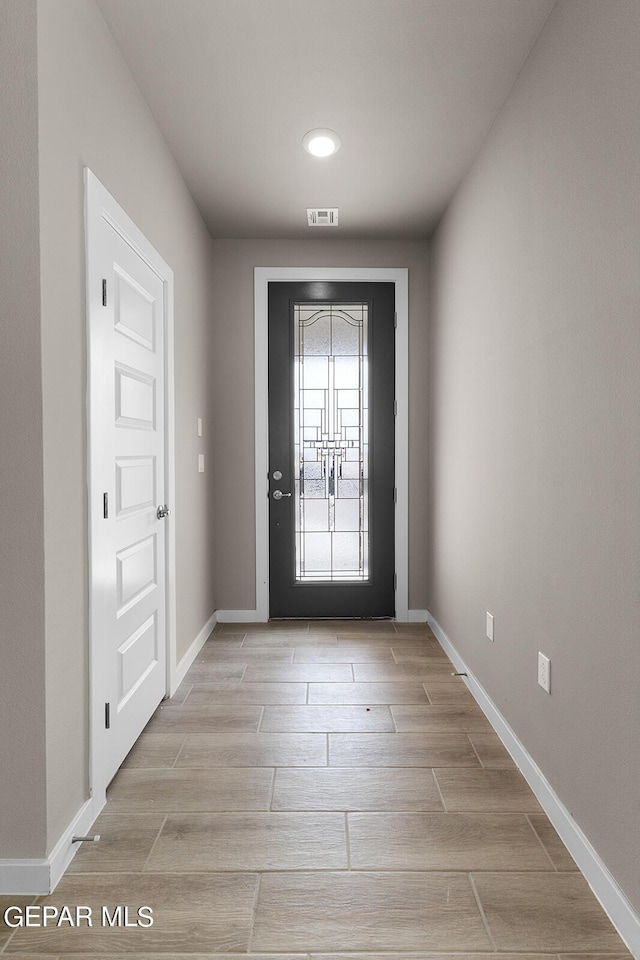 entryway featuring wood finish floors, visible vents, and baseboards