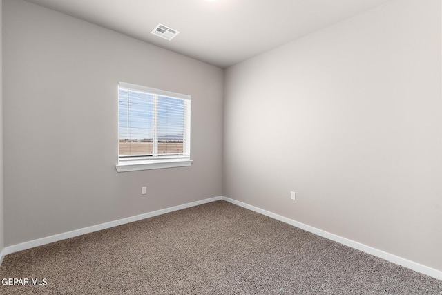 empty room featuring carpet flooring, visible vents, and baseboards