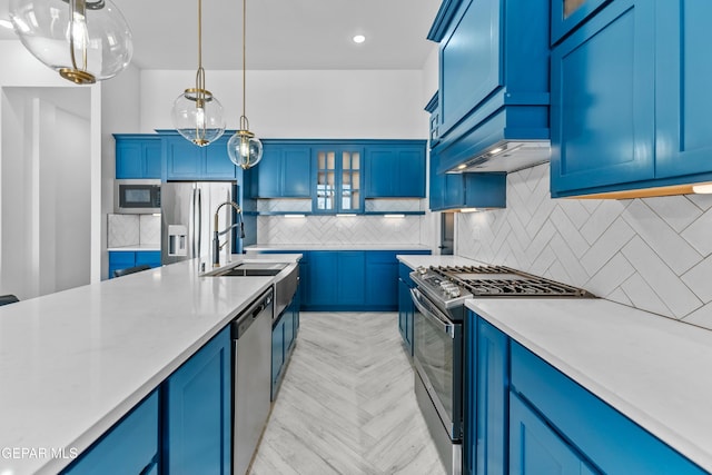 kitchen with hanging light fixtures, decorative backsplash, blue cabinets, appliances with stainless steel finishes, and sink