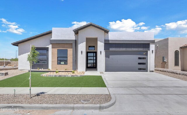 12869 Kingsbury Ave, Horizon City, TX 79928 - contemporary home featuring stucco siding, a front lawn, concrete driveway, and an attached garage