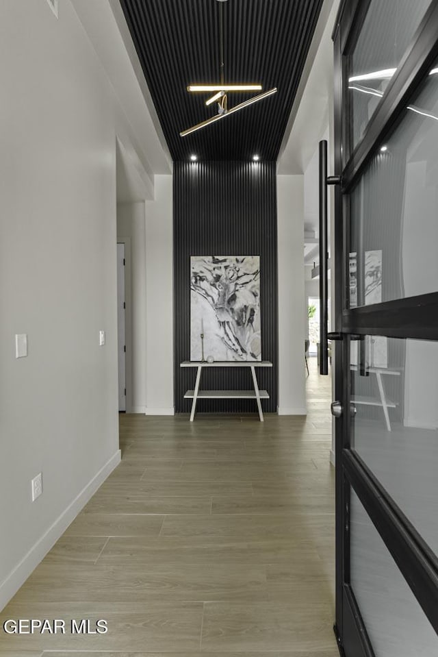 12869 Kingsbury Ave, Horizon City, TX 79928 - corridor with light wood-type flooring and a chandelier