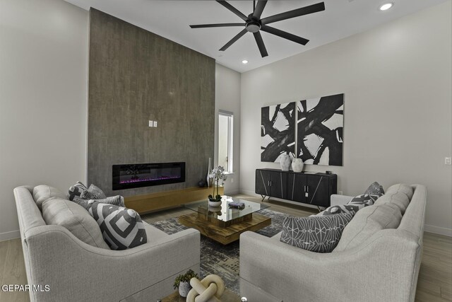 12869 Kingsbury Ave, Horizon City, TX 79928 - living room featuring a ceiling fan, wood finished floors, recessed lighting, and a glass covered fireplace