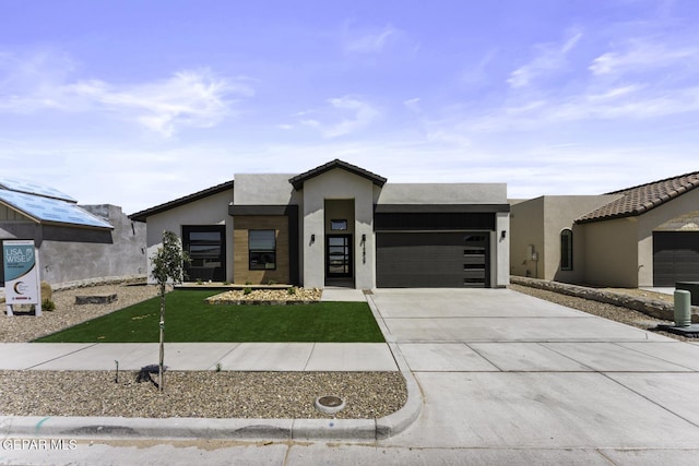 12869 Kingsbury Ave, Horizon City, TX 79928 - contemporary house with an attached garage, concrete driveway, stucco siding, and a front lawn