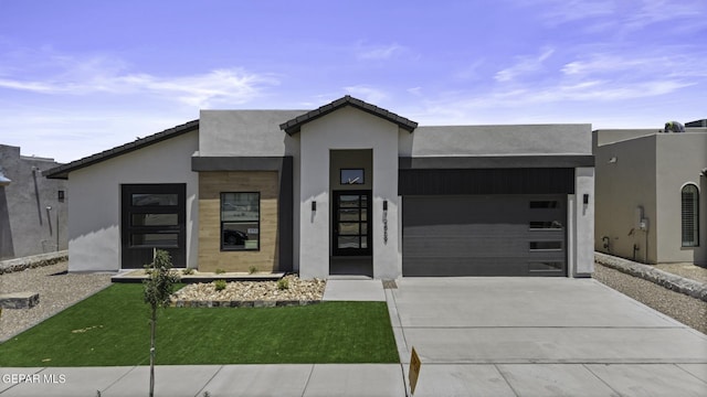 12869 Kingsbury Ave, Horizon City, TX 79928 - contemporary home with an attached garage, stucco siding, driveway, and a front lawn