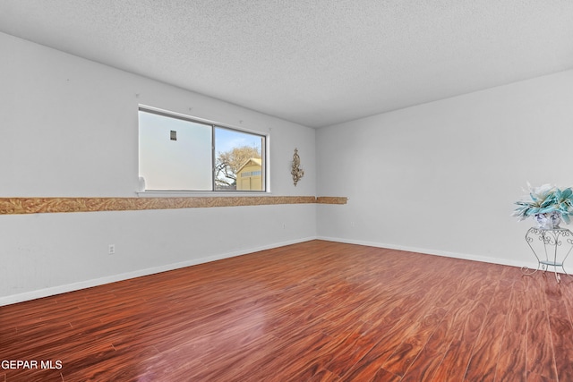 spare room featuring a textured ceiling and hardwood / wood-style floors