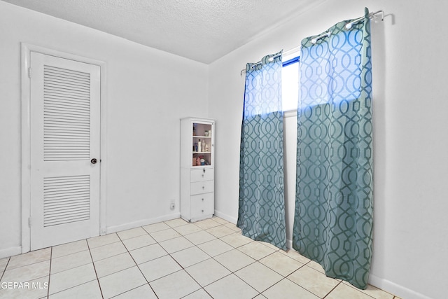 interior space featuring light tile patterned flooring and a textured ceiling