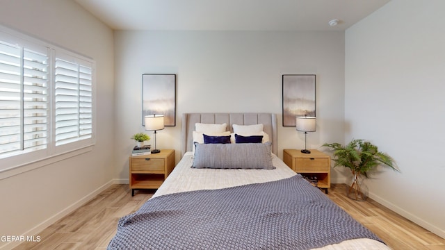 bedroom with light wood-type flooring and baseboards