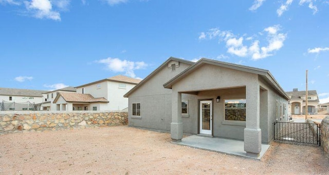 view of front facade with fence private yard, a patio, and stucco siding