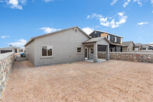 rear view of property with a fenced backyard, a residential view, and stucco siding