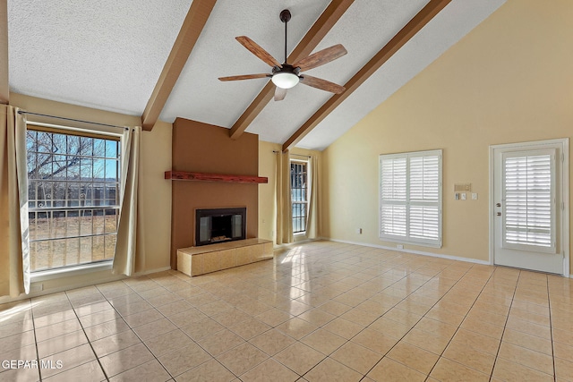 unfurnished living room featuring light tile patterned floors, ceiling fan, a textured ceiling, beam ceiling, and a tile fireplace