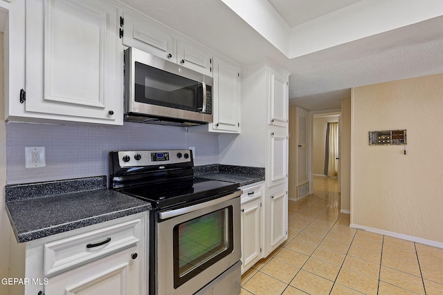 kitchen with white cabinets, appliances with stainless steel finishes, and light tile patterned floors