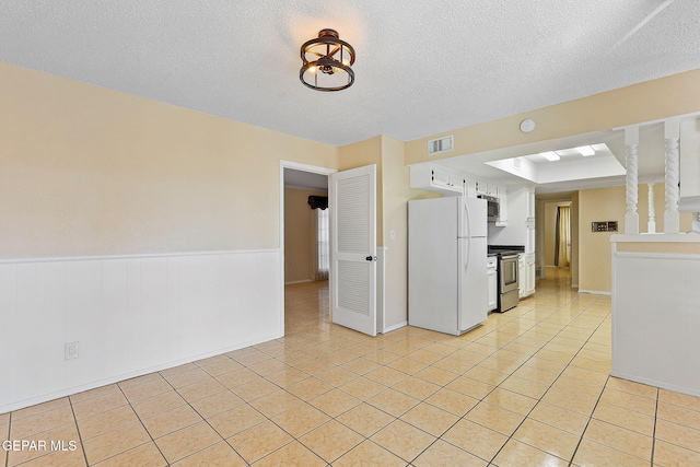 interior space featuring a textured ceiling and light tile patterned floors