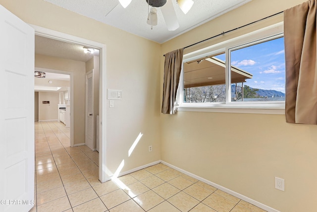 hall featuring a mountain view, a textured ceiling, and light tile patterned floors