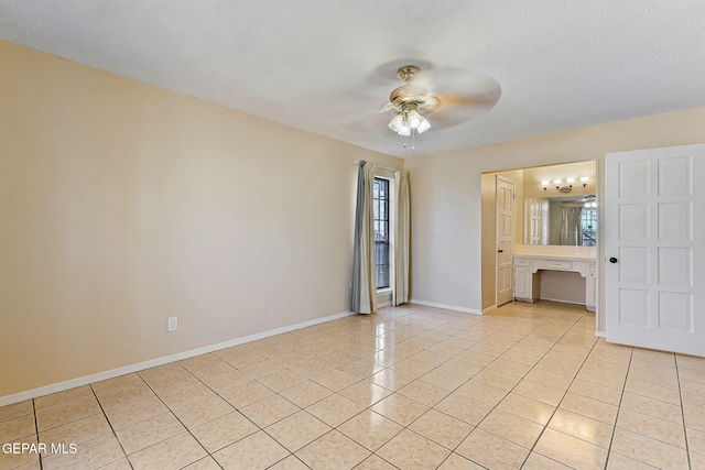 spare room with a textured ceiling, ceiling fan, and light tile patterned floors