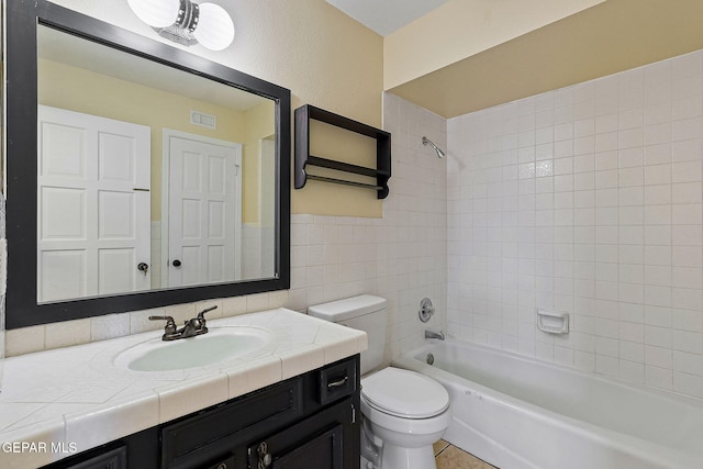 full bathroom with toilet, vanity, and tiled shower / bath