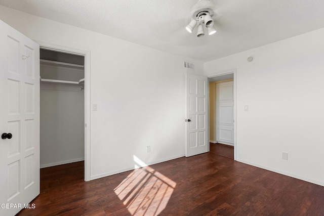 unfurnished bedroom featuring a closet and dark wood-type flooring