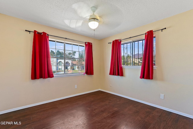 empty room with ceiling fan, wood-type flooring, and a textured ceiling