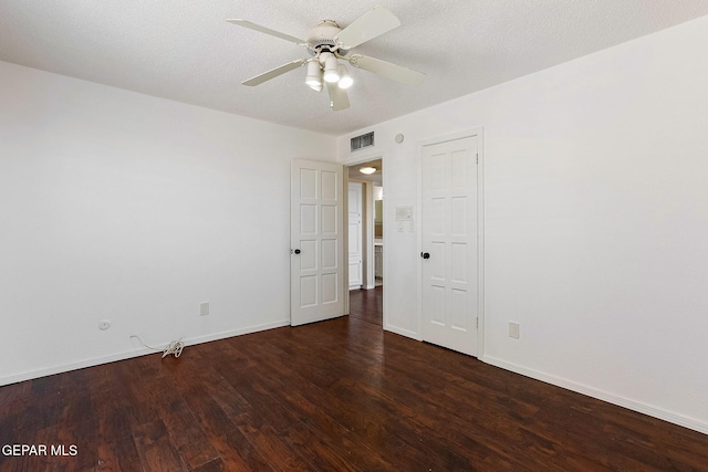 empty room with ceiling fan, a textured ceiling, and dark hardwood / wood-style floors