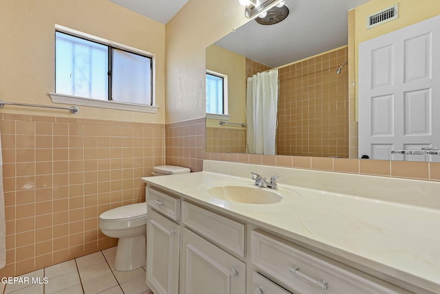 bathroom with toilet, vanity, tile walls, tile patterned floors, and a shower with curtain