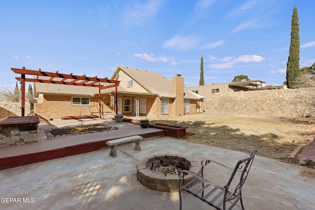 rear view of house with a pergola, an outdoor fire pit, and a patio